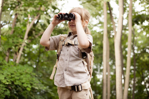 istock young girl scout, explores  nature with binoculars on camping trip 667248724