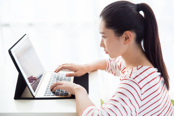 istock Young woman working with laptop computer at home 667248774