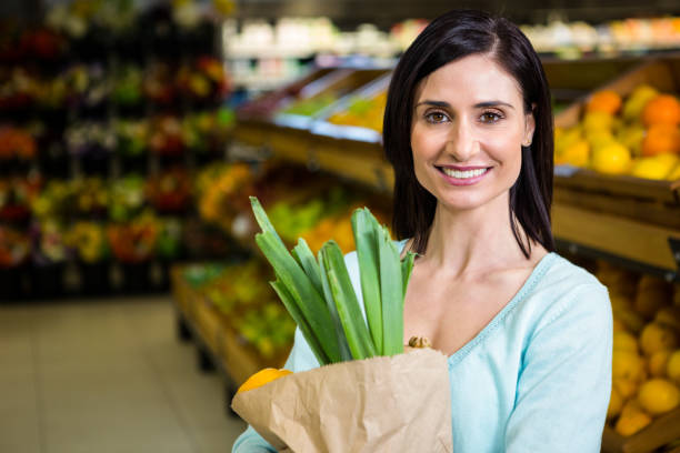 istock Smiling woman holding grocery bag 667248986