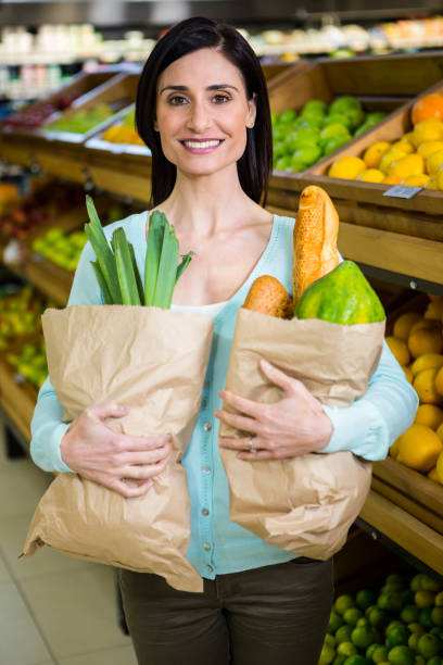 istock Smiling woman holding grocery bag 667249074