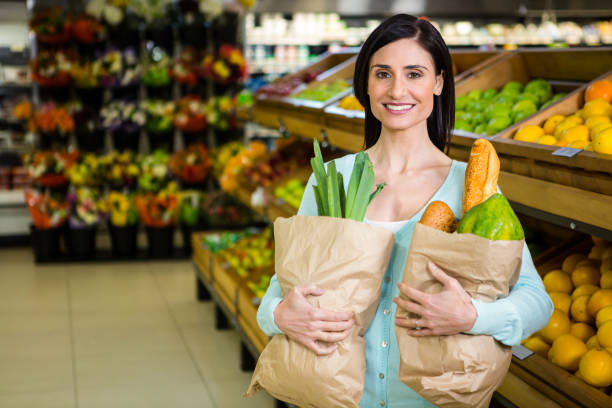 istock Smiling woman holding grocery bag 667249092