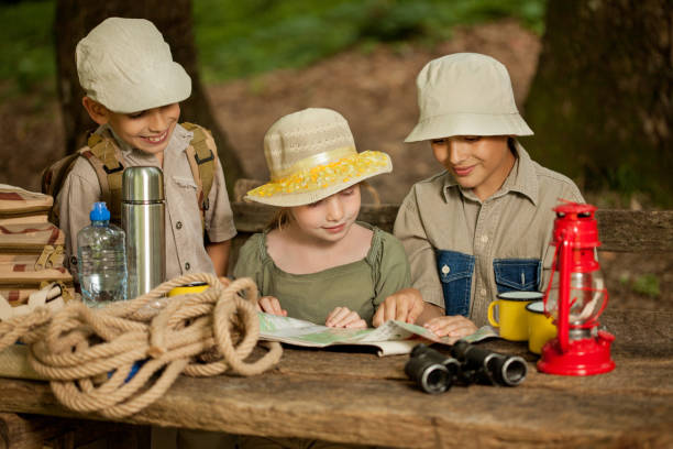 istock summer camps,scout children read map 667252174