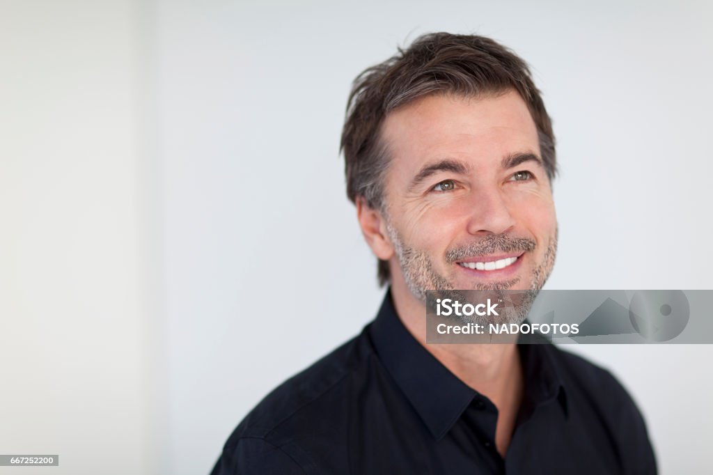 Mature Businessman Smiling and Looking Away. Isolated On White men, 50-59 years, mature men, smiling, isolated on white, healthy lifestyle, senior adult, attractive male, human face, tranquil scene, males, 40-49 years, success, portrait, male beauty, leadership, sales occupation, beard, fashion model, one person, casual clothing, adult, close-up, caucasian ethnicity, cool, confidence, indoors, copy space, brown hair, elegance, lifestyles, head and shoulders, positive emotion, glamour, human hair, satisfaction, aspirations, energy, joy, content, looking away, attitude, masculinity, green eyes, 50s Looking Away Stock Photo