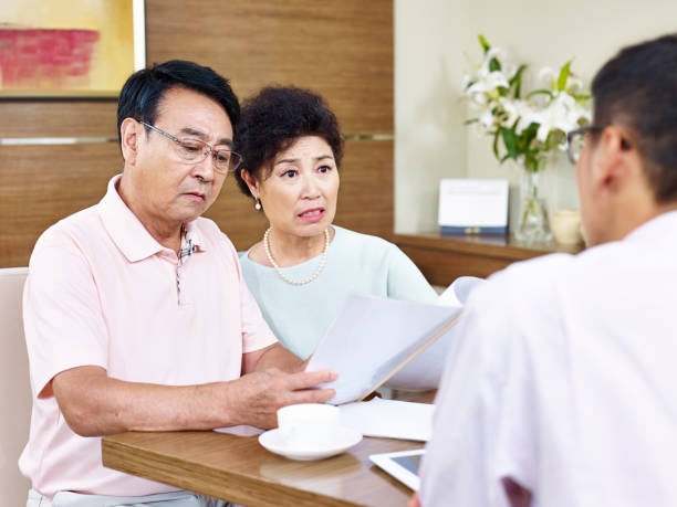 istock senior asian couple shocked while reading a contract 667252580