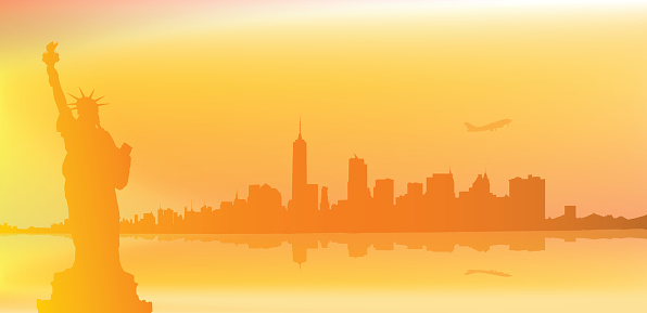 A vector illustration of the New York City skyline taken at sunrise or sunset with the Statue Of Liberty in the foreground and the city reflecting on the water of the Hudson river.
