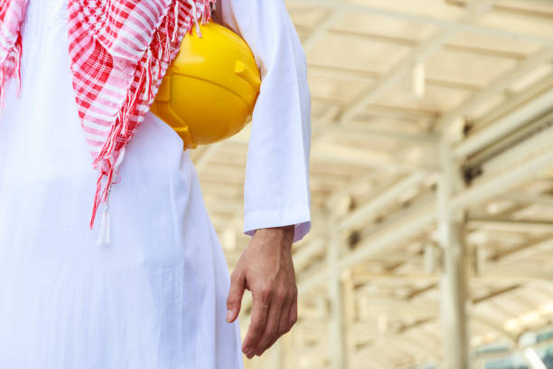 istock torso of arab engineer or worker hold in hand yellow helmet 667260494