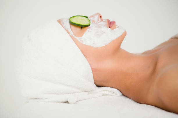 istock Relaxed woman with cucumber on a creamed face 667260568