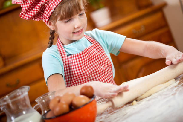 istock happy smiling young girl chef in kitchen,playing 667262642