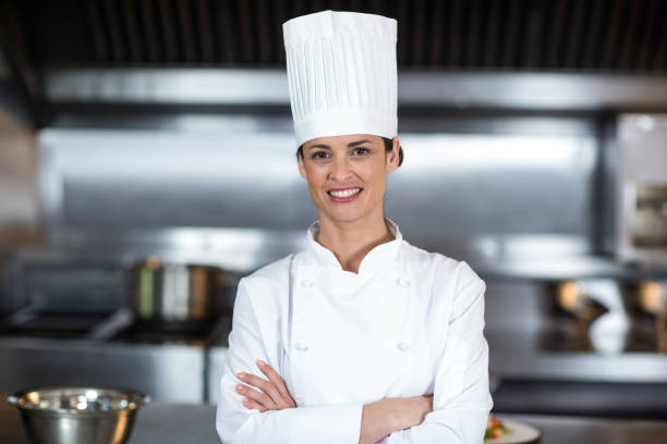 istock Portrait of smiling female chef standing in kitchen 667266898