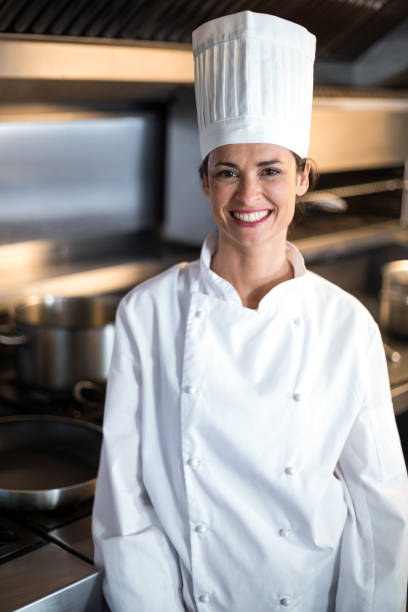 istock Portrait of smiling female chef standing in kitchen 667267548
