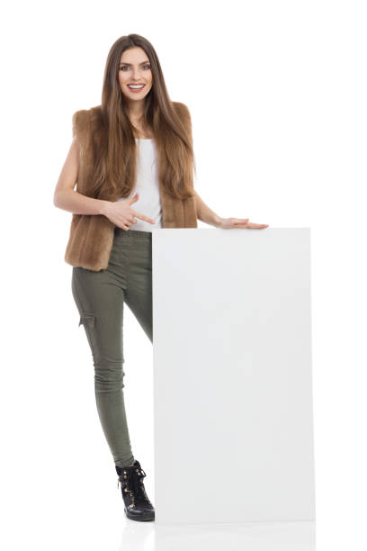 istock Woman In Fur Vest Pointing And Presenting 667267894