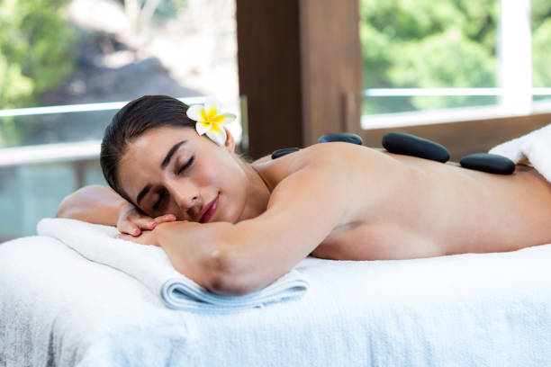 linda mulher a receber a massagem com pedras - massage therapist stone spa treatment working - fotografias e filmes do acervo