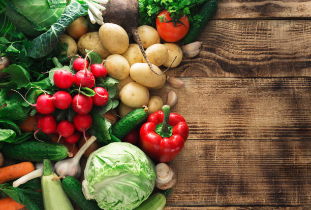istock Set of various fresh vegetables on a wooden table with border, top view 667270994