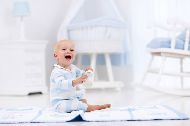 istock Baby boy drinking milk in sunny nursery 667274770