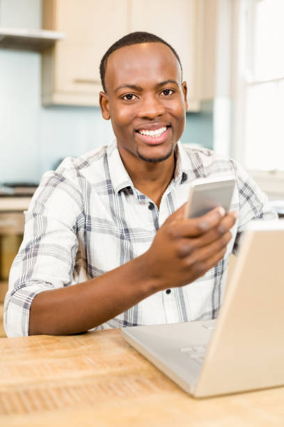 istock Handsome man holding smartphone in the kitchen 667284442