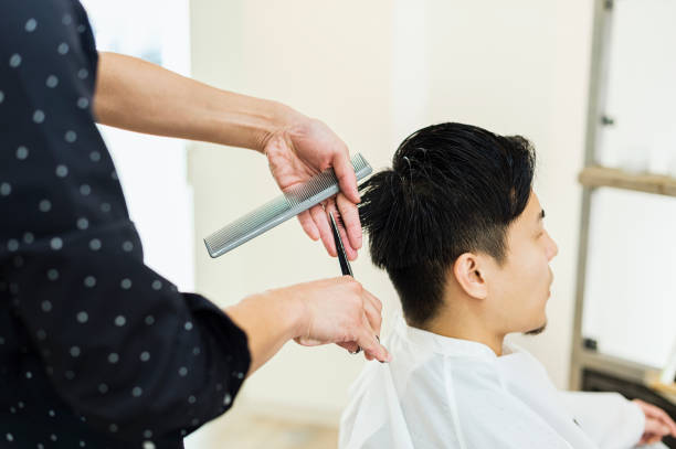 若い成人男性の脱毛スタイリスト オーナー カット男の髪 - 髪を切る ストックフォトと画像
