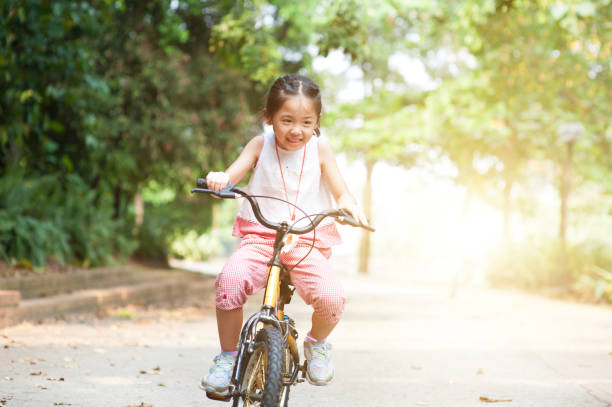 istock Active Asian child riding bicycle outdoor. 667288330