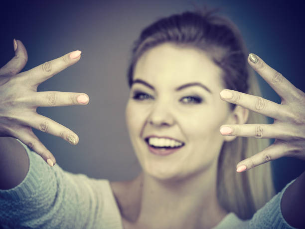 Small hand sign. Young woman doing a sign for a small thing with the fingers. Focus on the fingers.