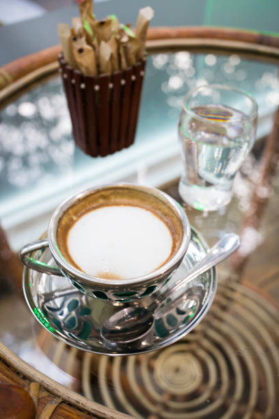 cup of hot cappuccino on a glass coffee table in a small cafeteria in Kandy; Sri Lanka