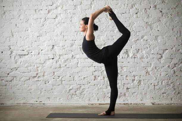 young yogi attractive woman in lord of the dance pose - shiva posture imagens e fotografias de stock