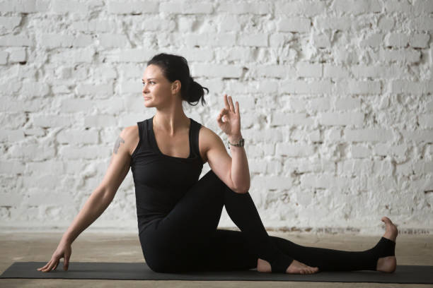istock Young yogi attractive woman in Ardha Matsyendrasana pose, white loft 667293806