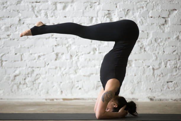 istock Young yogi attractive woman in headstand pose, white loft background 667293876