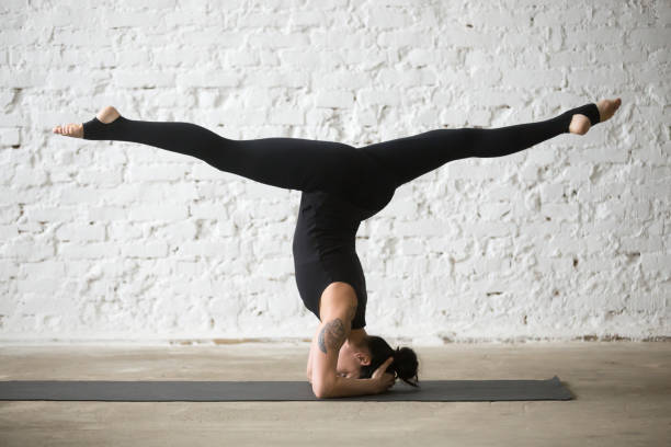 istock Young yogi attractive woman doing salamba sirsasana pose with splits 667293896