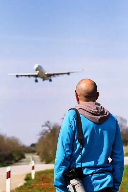 Man is spotting airplane. Spotting Airplane. Man is looking at the plane which is landing. Aircraft spotting concept.