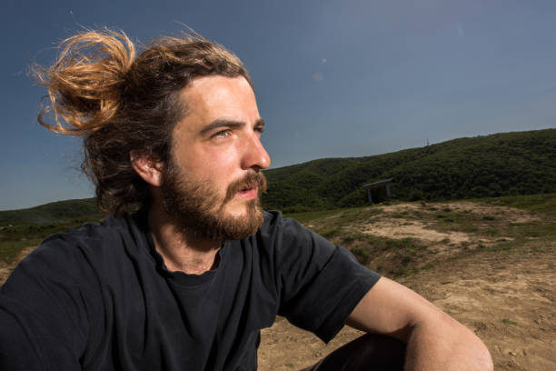 istock Young pensive man relaxing in nature and looking away. 667297576