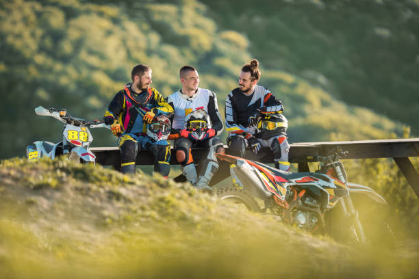 istock Young dirt bike races talking while resting in nature. 667298044