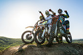 Team of successful motorcyclist on top of the hill.