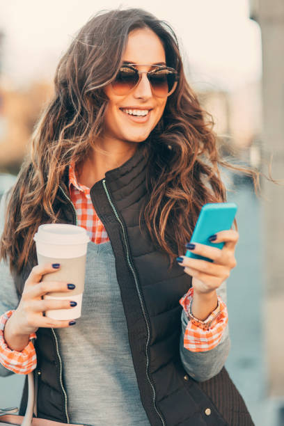 istock Woman texting and drinking coffee outdoors. 667301026