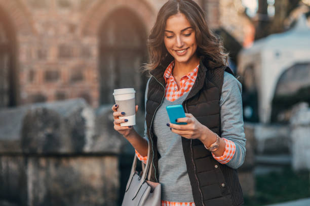 istock Woman texting and drinking coffee outdoors. 667301032
