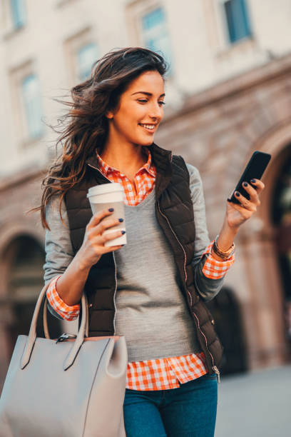 istock Woman texting and drinking coffee outdoors. 667301034