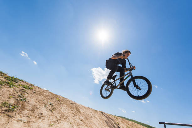 istock Below view of man on bicycle jumping against the sky. 667301128