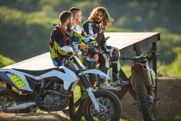 istock Three motocross riders relaxing in nature after race. 667301740