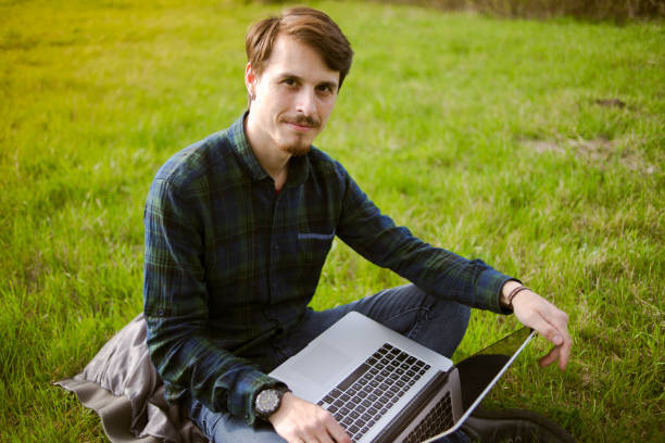 istock Man with laptop on the lawn 667302124