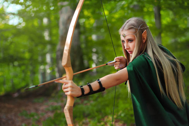istock Beautiful female elf archer in the forest hunting with a bow 667304816