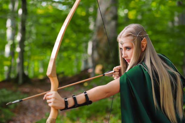 istock Beautiful female elf archer in the forest hunting with a bow 667304852