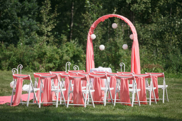 registrazione del matrimonio bella in natura. sedie bianche per la registrazione in visita. tenda rosa con fiori bianchi per la registrazione all'uscita. dettagli del matrimonio - studio shot flash foto e immagini stock