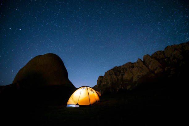 istock Glowing tent in the mountains under a starry sky 667312726