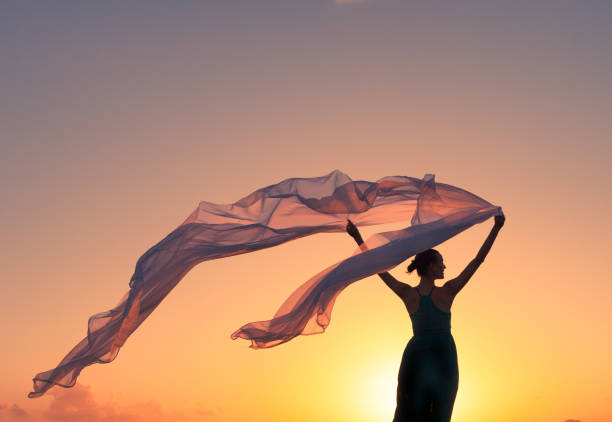 istock Beautiful woman holding silk cloth in the wind 667313082