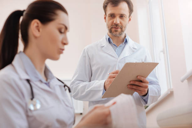 istock Skillful precise doctor seeking colleagues consultation 667319454