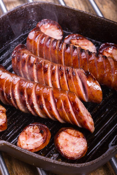 Fried pork sausages on a cast iron skillet. stock photo