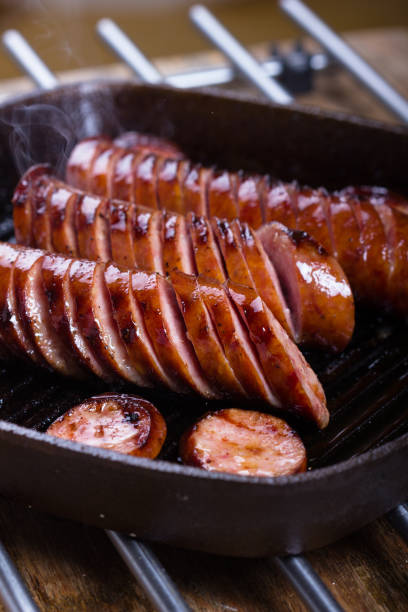 Fried pork sausages on a cast iron skillet. stock photo