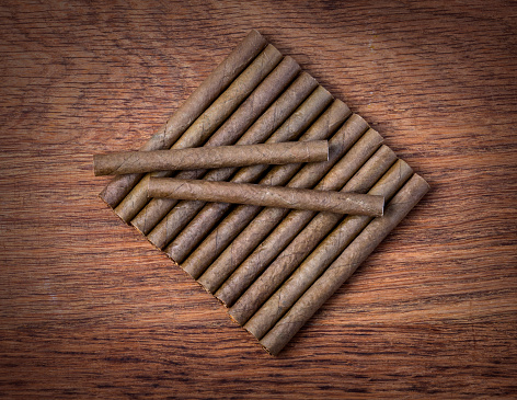 Cigarillo on wooden background close up