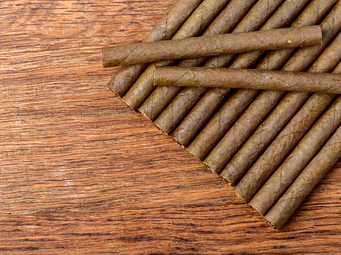 Cigarillo on wooden background close up