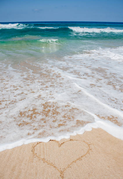 istock Heart shape in sand on clear beach 667337090