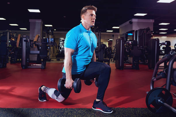 istock Athlete with dumbbells doing exercises squats in the gym 667337366