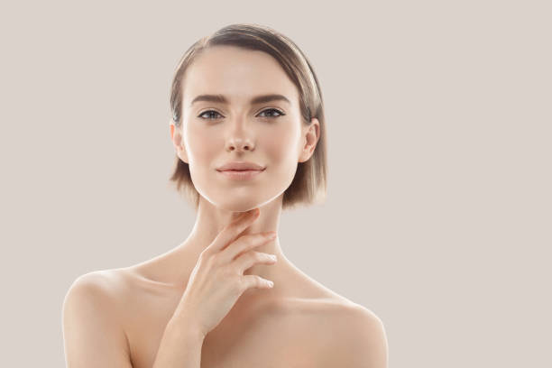 Beauty Woman face Portrait. Beautiful model Girl with Perfect Fresh Clean Skin. Beauty Woman face Portrait. Beautiful model Girl with Perfect Fresh Clean Skin. Blonde short hair Youth and Skin Care Concept. Isolated on a gray background neck photos stock pictures, royalty-free photos & images